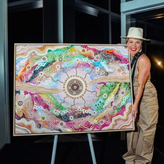 Pink smiles next to her new work of art.